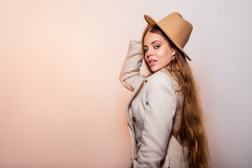 Fashion Portrait Beautiful Young Woman in a light fashionable coat and a beige stylish hat  