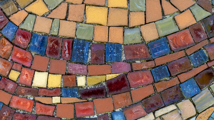 Altes verschmutztes Vintage Mosaik aus farbigen Stückchen in Nahaufnahme an einer verwitterten Außenwand