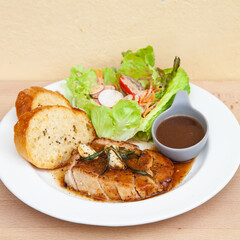 Pork sirloin steak with gravy sauce, salad and garlic bread