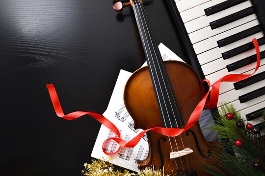 Christmas performance concept with violin and piano on black table