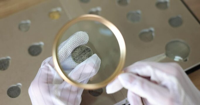 Numismatist examines coin from ancient collection
