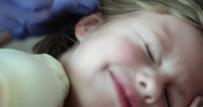 Girl with otitis media and ear pain is given medicine drops in ear