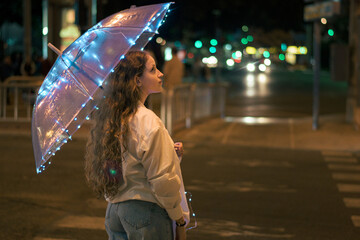 Portrait of a young woman with a umbrella with lights at night