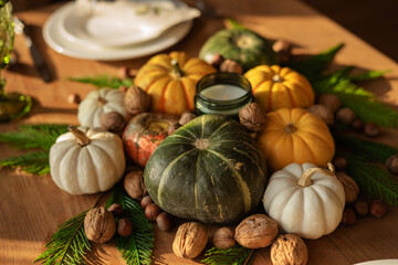 Festive Thanksgiving table. Fresh white, green and yellow pumpkins on a wooden table.