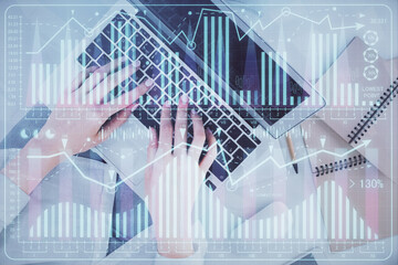 Double exposure of woman hands working on computer and forex graph hologram drawing. Top View. Financial analysis concept.