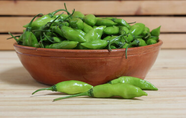Bowl of Fresh Green Aji Limo Chili Peppers on Wooden Table