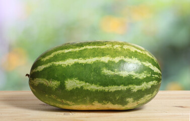 Fresh Watermelon on Wooden Table With Green Nature Blur Background