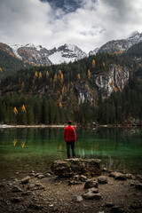 A person with a red jacket looking toward the snowy dolomites