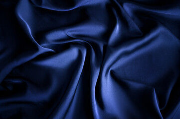 Texture, background, pattern. Texture of blue silk fabric. Beautiful blue silk fabric. dark blue...