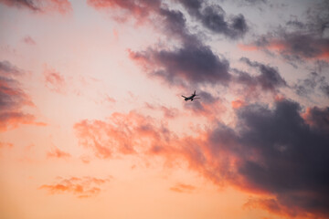 A plane flying in the sky during a colorful sunset