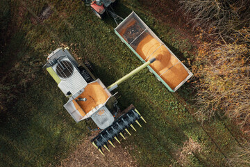 aerial view of a harvester unloading the corn into the trailer, effective harvest
