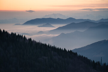 Naklejka na ściany i meble Layers of hills in the bacground and low altitude clouds during dusk, Northern Italy