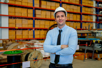 Portrait of business manager man stand in front of stack or shelves with parcel boxes in warehouse workplace area.