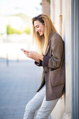 Profile of young woman messaging using smartphone in city