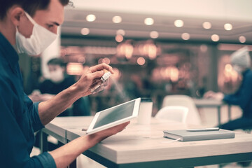 close up . young man spraying antiseptic on his digital tablet