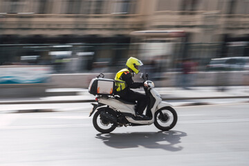 Obraz na płótnie Canvas Delivery guy driving a scooter with take away box