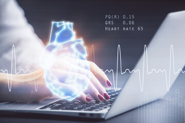 Double exposure of woman hands typing on computer and heart hologram drawing. Education concept.