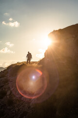 Silhouette of a hiker during sunset, with lens flare