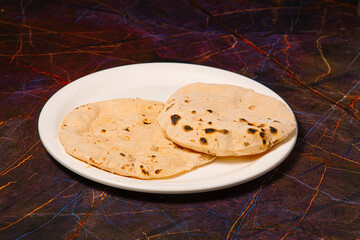 Indian Traditional Cuisine Chapati or Roti, or Indian Bread in white plate with flour