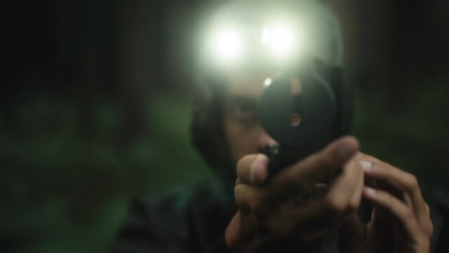 Researcher orients himself in the forest of the mountain with compass at night