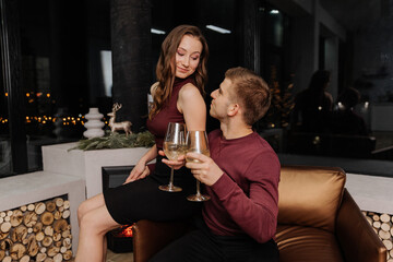 Young couple in love celebrating christmas together with a glass in their hands