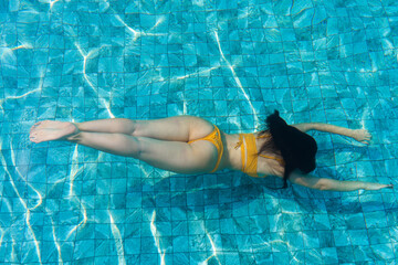 The girl dives under the water in the pool