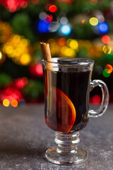 glass of hot mulled wine with cinnamon stick and orange