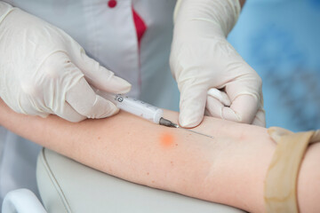 Close-up hand of a nurse, doctor or medical technologist in medical gloves takes a blood sample...