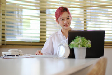 Online consultation remotely with a doctor discussing treatment and care using a laptop in her office. Health care, medicine and consultation with a friendly female doctor