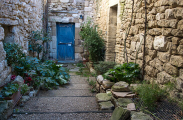 Fototapeta na wymiar petite cour d'une maison en pierre avec porte bleue