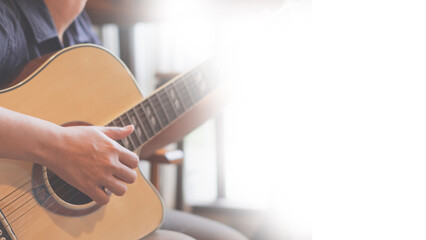 Musician is sitting and playing an acoustic guitar with white copyspace background. Concept of...