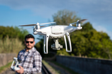 Hombre con lentes jugando con su drone en vuelo. Fotografía con enfoque selectivo en el drone