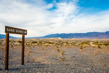 Beautiful shot of a wooden direction sign to the Mesquite Sand Dunes in Death Valley