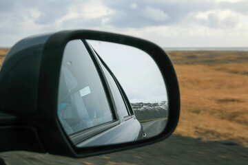 Rear view mirror with mountain road by winter