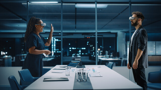 Office Online Meeting Video Conference Call: Businesswoman and Businessman Wearing Virtual Reality Glasses Talk using Augmented Reality Metaverse. Ultra Realistic Hologram of Virtual Employee Concept.