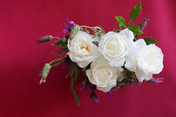 Natural white roses bouquet in dark red background