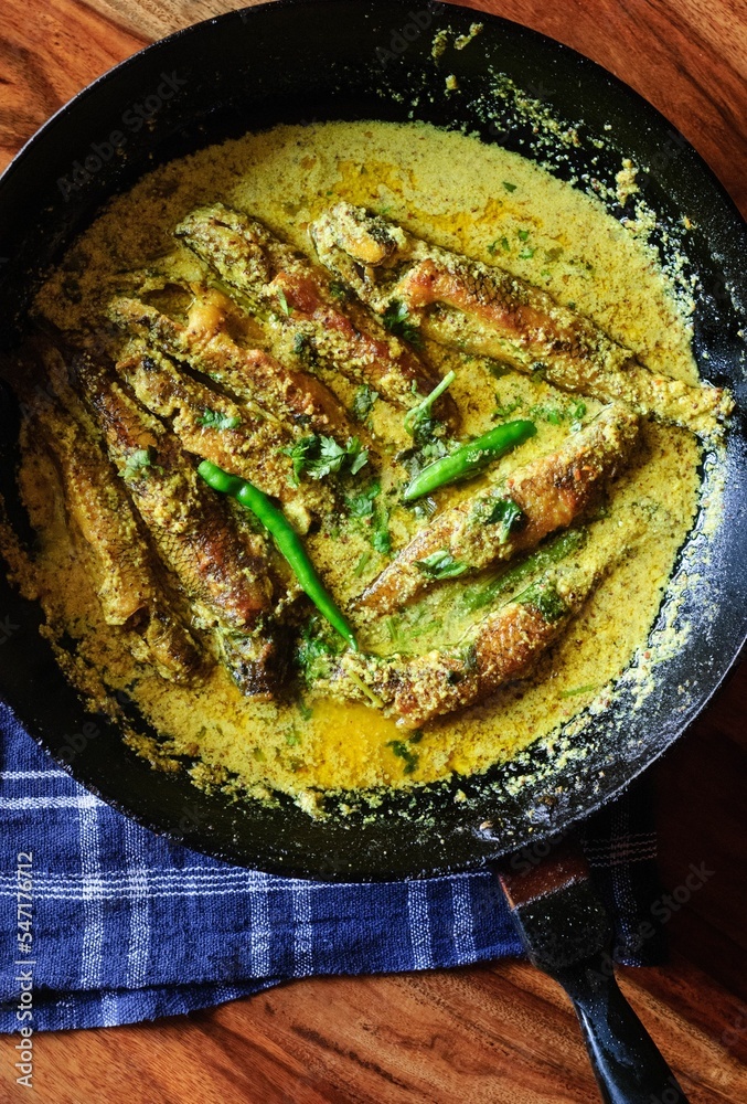 Poster Vertical shot of tasty fish curry in a pan