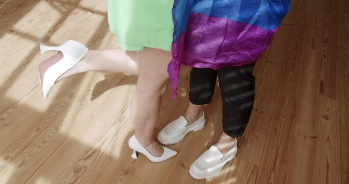 Lgbt women couple rest at home. Embrace and holding each other with pride rainbow flag. the woman's leg rises romantically during the kiss. lesbian couple enjoying. LGBT rights, Lesbian family.