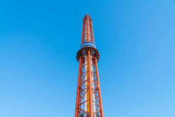 free fall attraction with people on a blue sky background