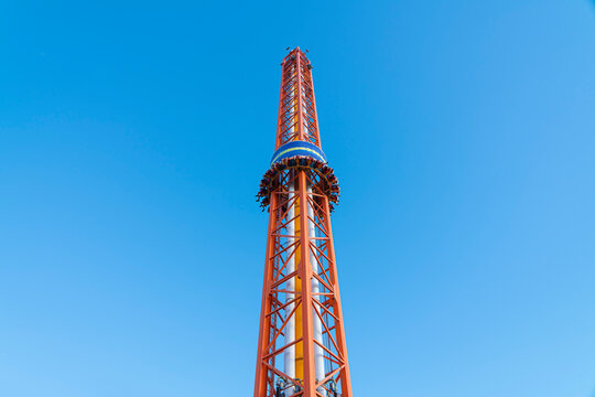 free fall attraction with people on a blue sky background