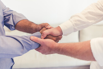 Closeup of hands of two businessmen shaking hands,making a deal, agreeing to a partnership. Two professionals greeting each other with a handshake, planning for the future in a meeting.