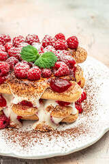 berry tiramisu with biscuit with coffee cream and fresh berries. Tiramisu with raspberry on a light background
