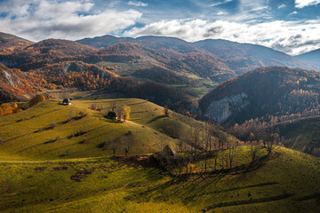 Visit Transylvania, Romania. Aerial view of Dumesti village with traditional old houses at the bottom of Apuseni Mountains in autumn color.