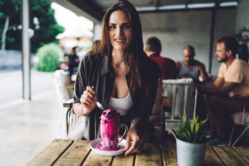 Smiling woman enjoying exotic beverage in cafe