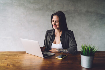 Smiling woman working on netbook at workplace