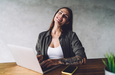Cheerful woman with laptop in cafe