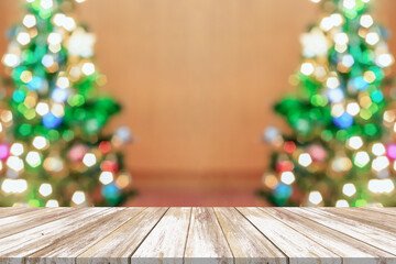 Fototapeta na wymiar Empty wood table top with blur Christmas tree with bokeh light background
