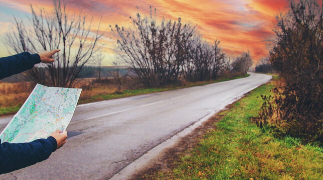 A man looks at a map on the road. Selective focus.