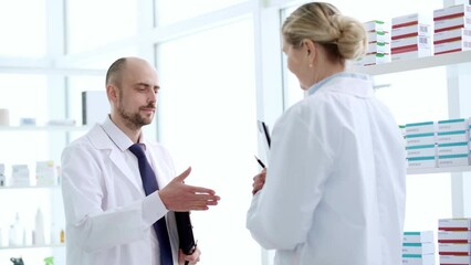 adviser is checking the availability of the necessary medicines on the shelves of the pharmacy.