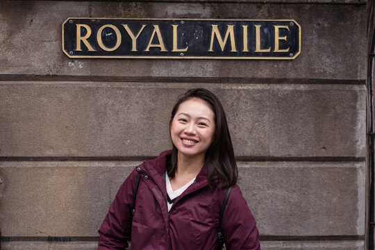 Happy Asian woman under Royal Mile sign